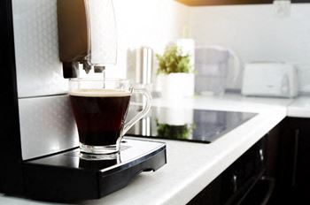 a coffee maker making a cup of coffee on a kitchen counter